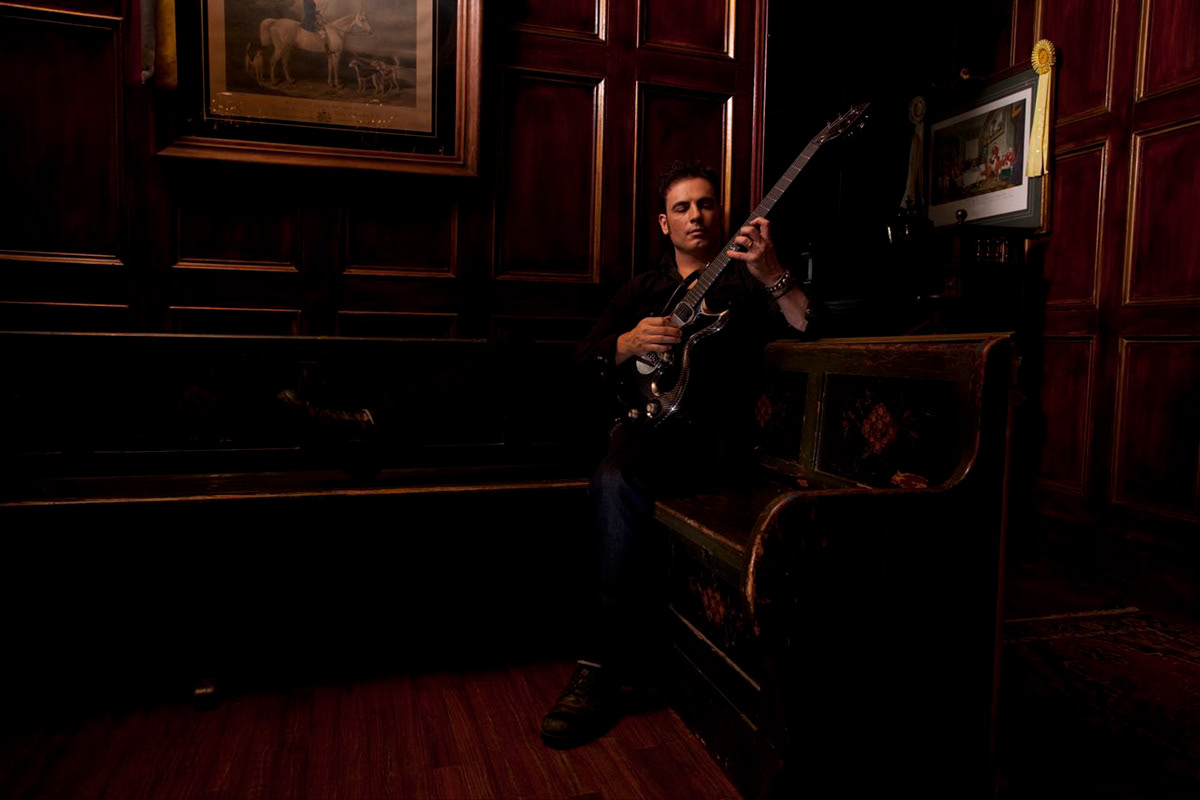 Rod DeGeorge playing guitar in the dark wood interior