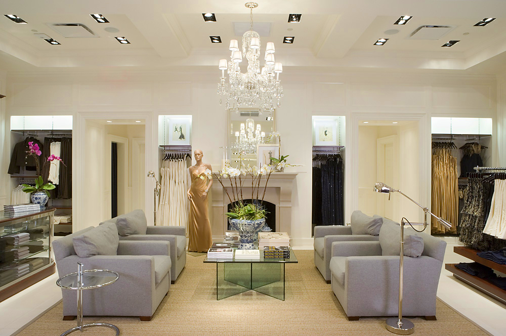 Selling floor with crystal chandelier, fireplace and grey upholstered armchairs