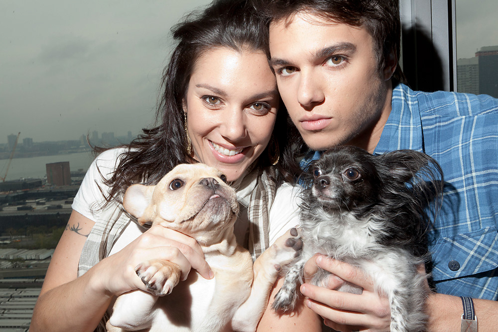 Chris Riggi and his sister holding their dogs by the window