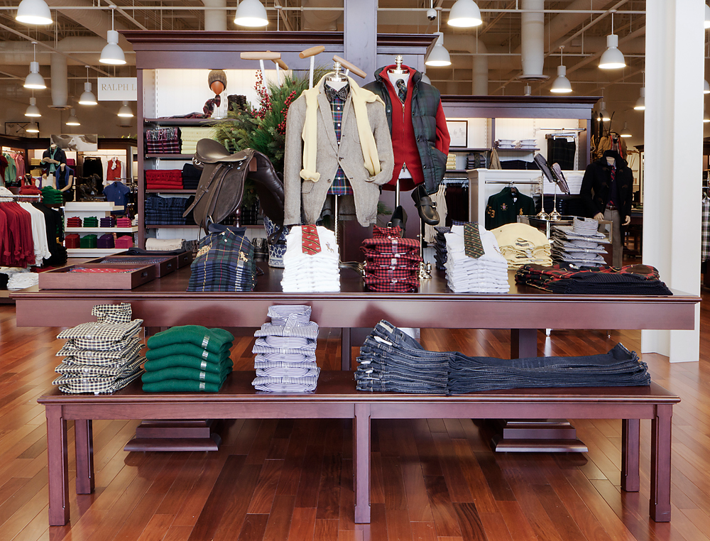 Menswear table with plaid shirting, tweed jacket and an equestrian saddle