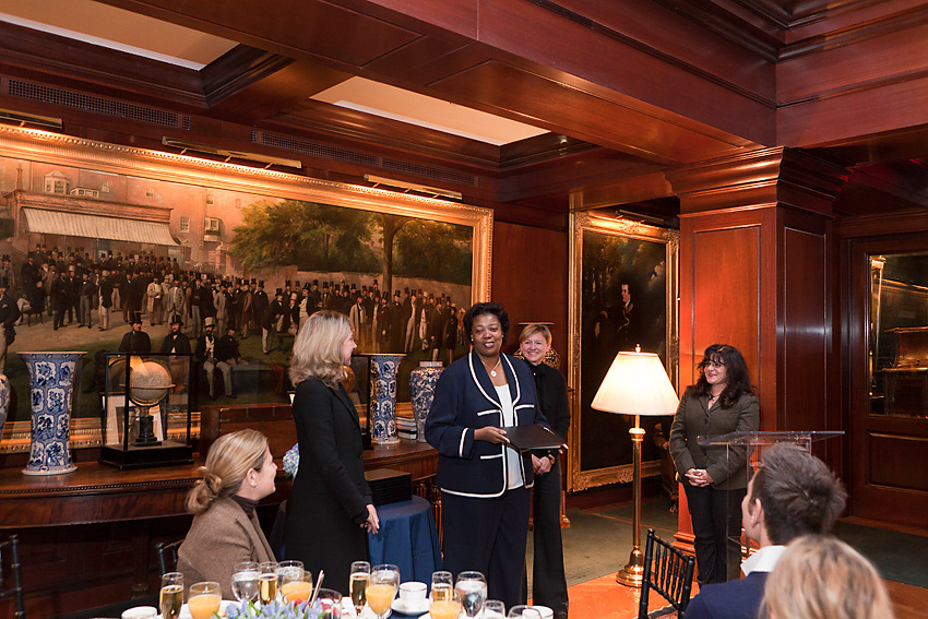 Honoree being recognized before a large period painting