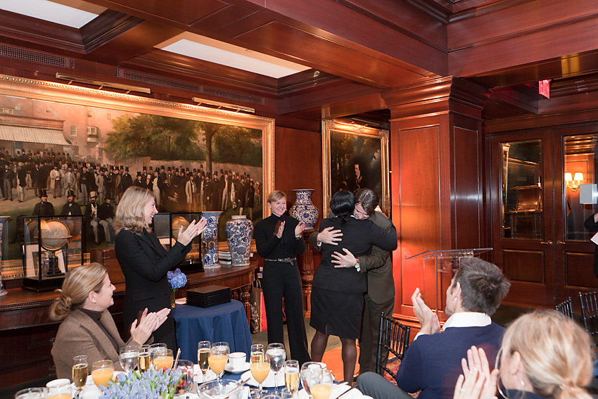 Guests applauding as an honoree is congratulated