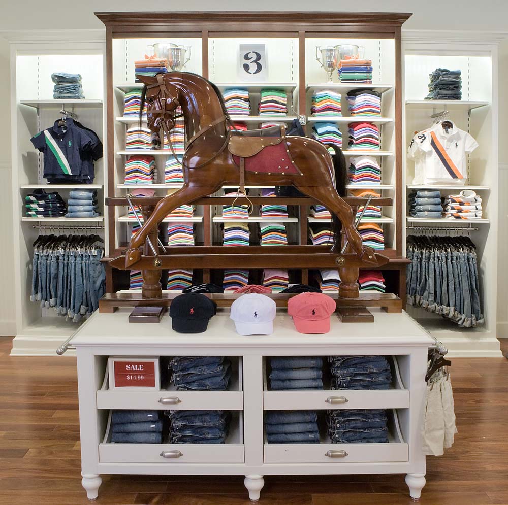 Wooden rocking horse in front of shelves of colorful Polo shirts