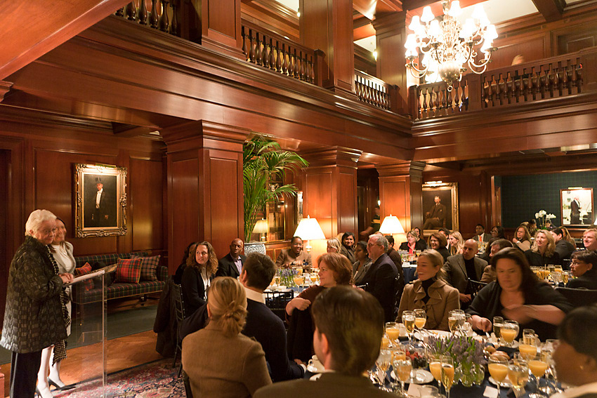 Speaker addressing guests seated at round tables