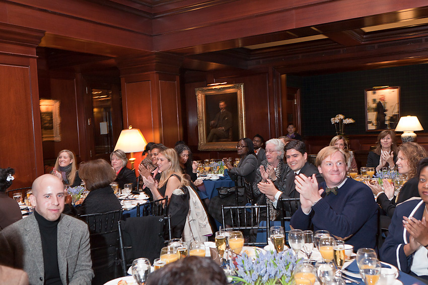 Guests applauding from their luncheon tables