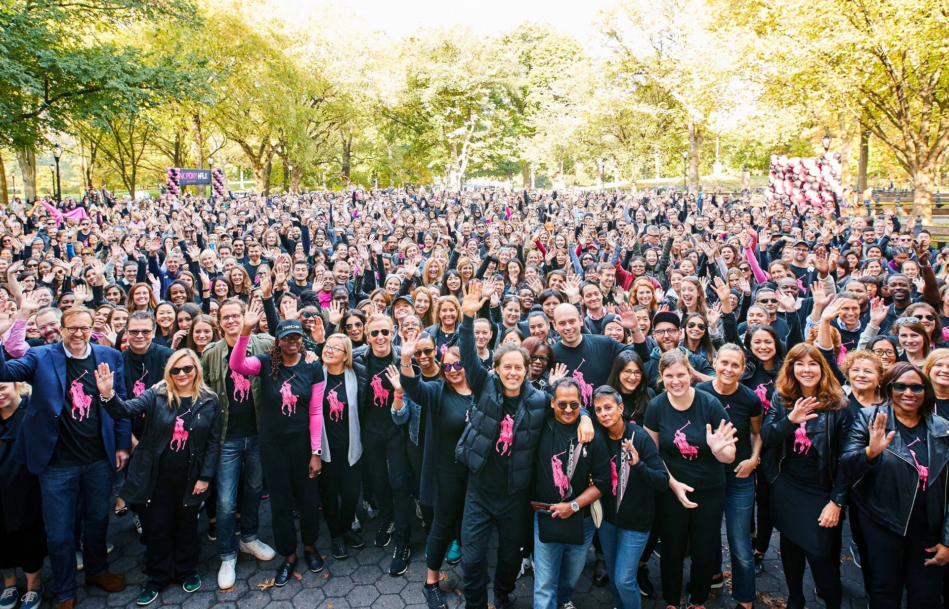 Hundreds of Ralph Lauren employees in Pink Pony tees waving together in Central Park at the Pink Pony Walk
