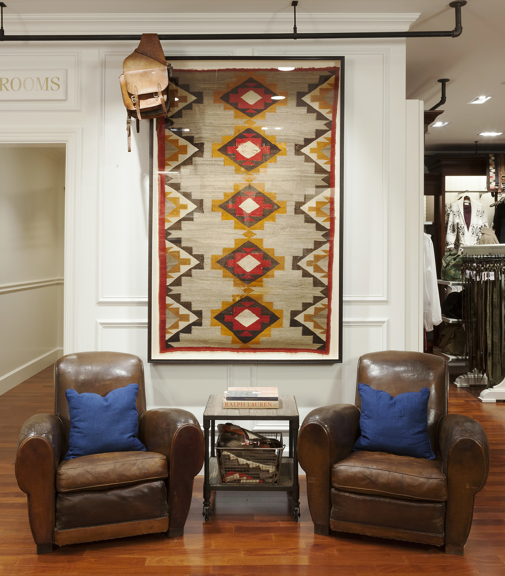 Framed Southwestern textile above two aged leather club chairs
