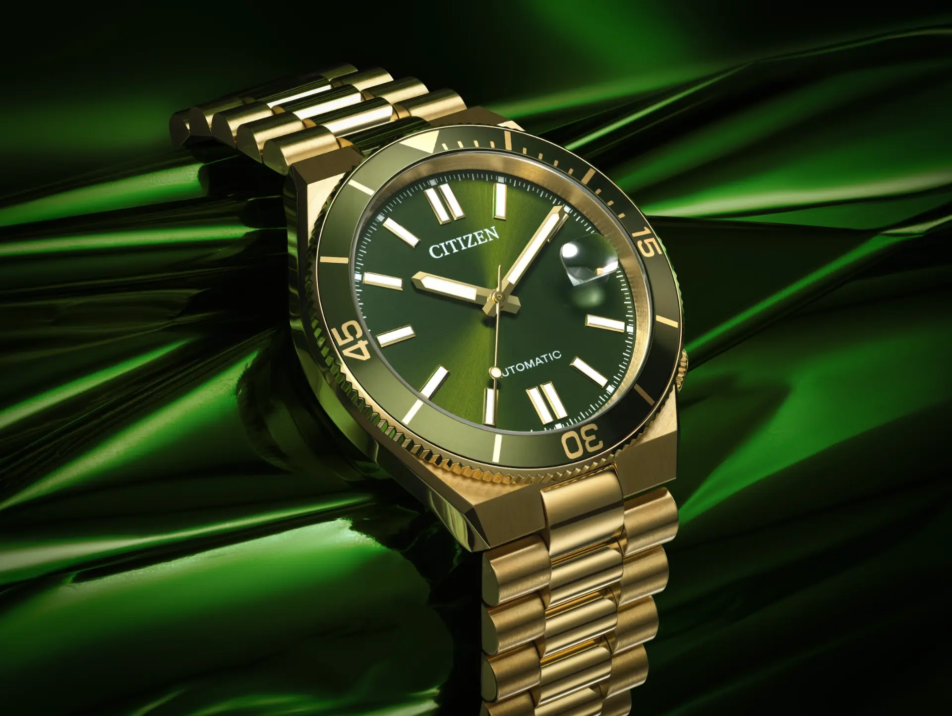 Citizen automatic watch with green dial and gold bracelet against reflective green fabric