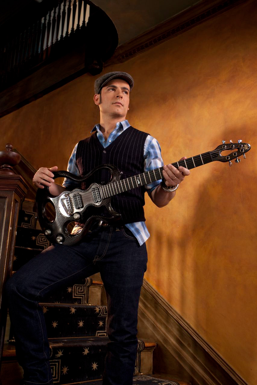 Rod DeGeorge in the finished look: plaid shirt, dark vest and denim, with guitar
