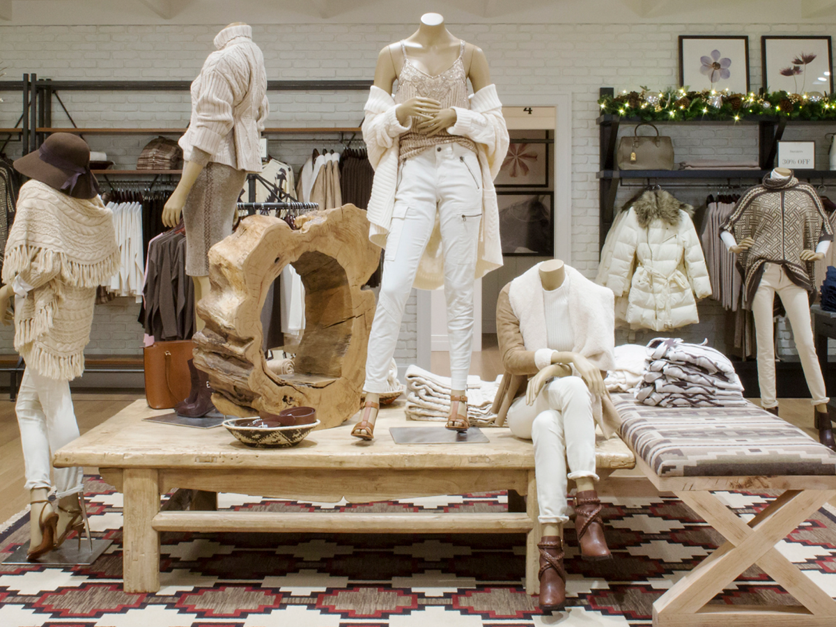 Ralph Lauren retail environment with mannequins on a rustic table over a southwestern rug