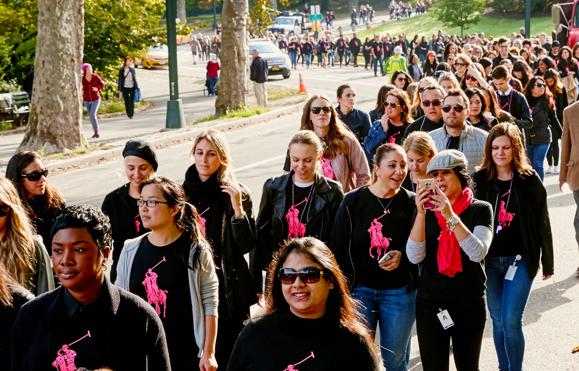 Crowd of Ralph Lauren employees in Pink Pony tees walking through Central Park at the Pink Pony Walk
